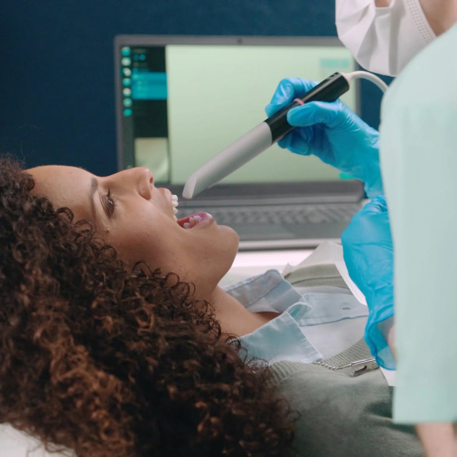 A woman getting scanned for her custom mouthpiece