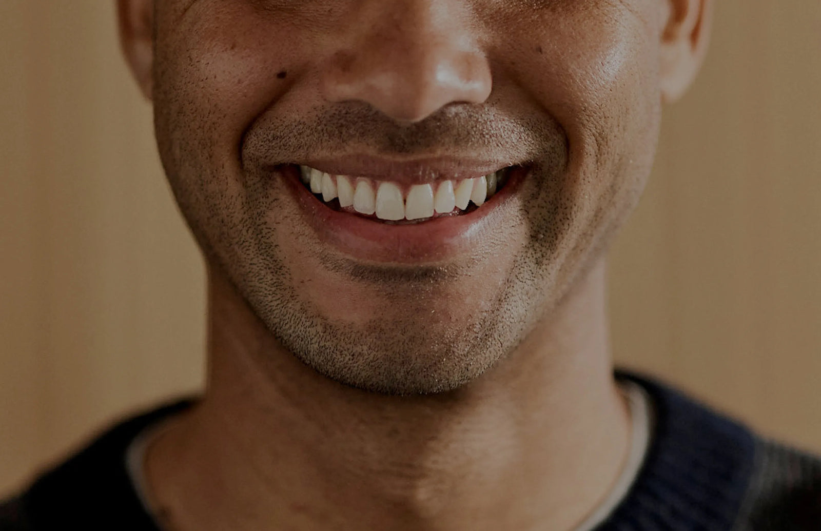 Photo of a man smiling with a close of up of his teeth