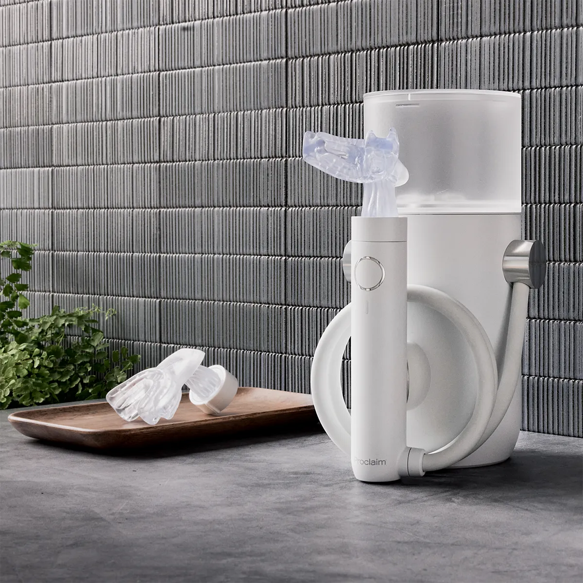 The Proclaim Custom-Just Oral Health System with an additional mouthpiece next to it in a bathroom setting