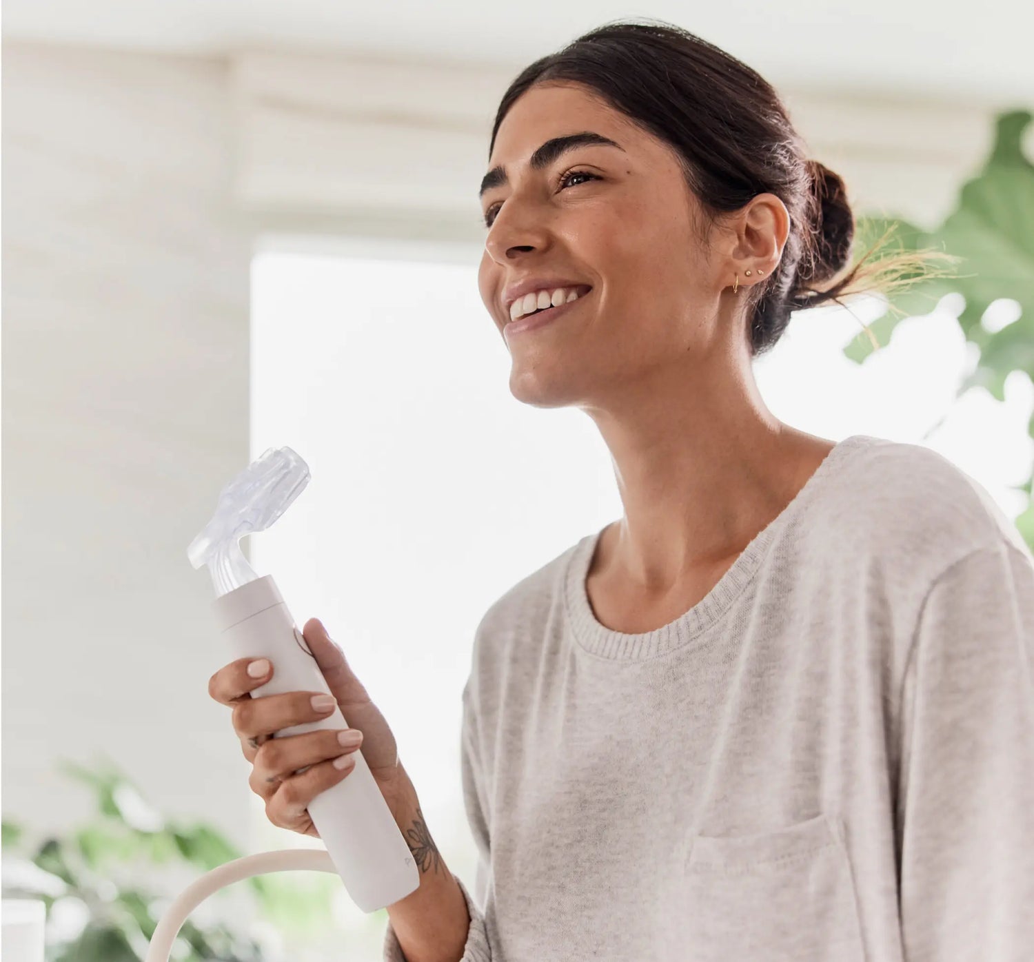 Woman Looking into her bathrom mirror as she uses her Proclaim Oral Health System