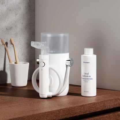 The Proclaim Oral Infusion Concentrate next to the Proclaim Custom-Jet Oral Health system on a wood countertop in a bathroom